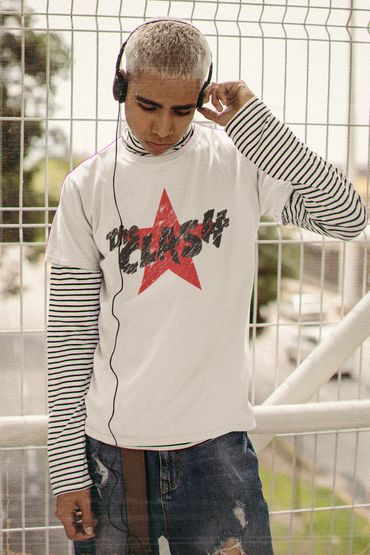 Young man with headphones wearing a striped long-sleeve under a white Clash t-shirt.