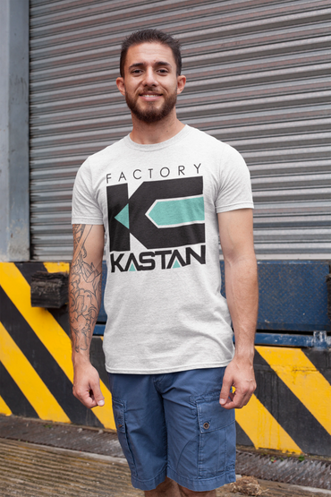 Man wearing a white 'Factory Kastan' t-shirt and blue shorts, standing outdoors.