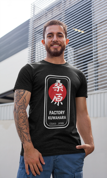 Smiling man with a tattoo wearing a black 'Factory Kuwahara' t-shirt.