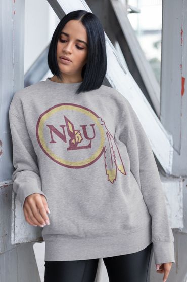Woman in gray NAU sweatshirt leaning against a metal structure.