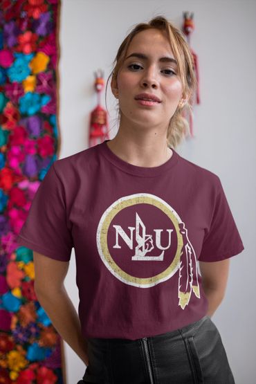 Young woman wearing a maroon t-shirt with a Native American-inspired logo and black leather pants.
