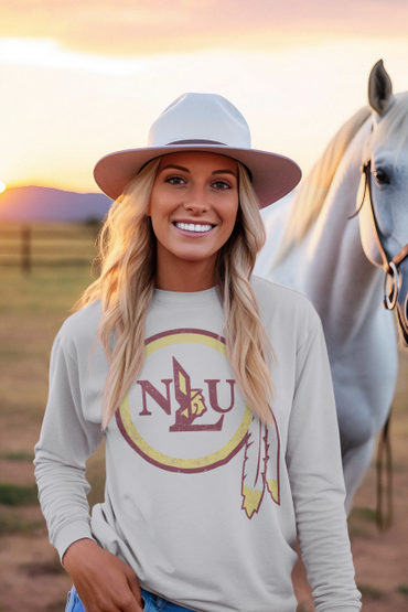Smiling woman in hat standing beside a white horse at sunset.