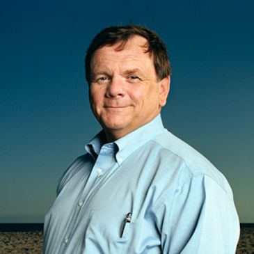 Man in a blue shirt standing outdoors.