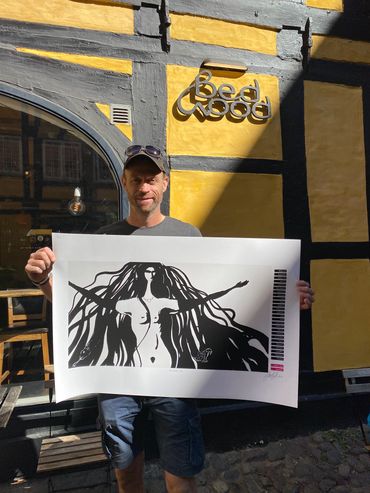 A man holding a poster from the Wilderness State Poem Book, better free than loved.