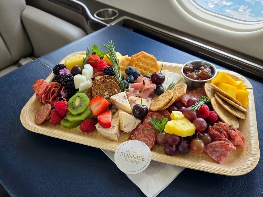 A colorful charcuterie board with fruits, cheeses, crackers, and meats on a tray.