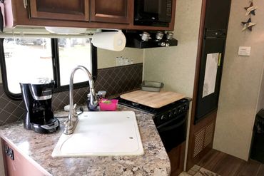 Trailer Rental #145 features a full kitchen with coffee pot, microwave and refrigerator.