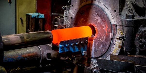 Metal being heated red-hot in an industrial furnace.