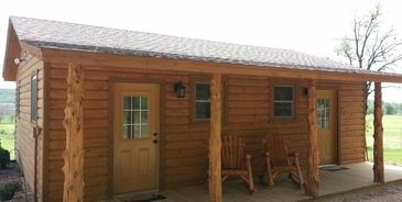 Small log cabin porch with rocking chairs.