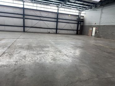 Empty industrial warehouse with concrete floor and metal walls.
