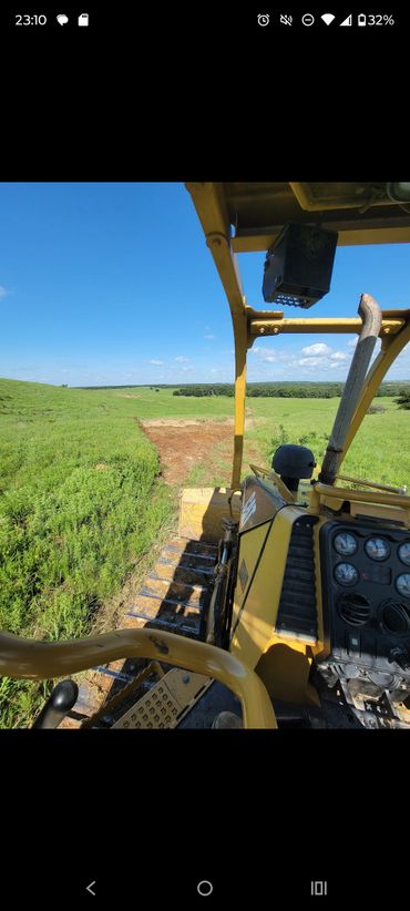 View from a bulldozer clearing land on a sunny day.