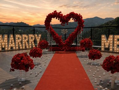 Romantic outdoor marriage proposal setup at sunset.