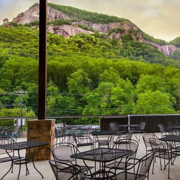 Empty outdoor seating area with scenic mountain and forest view.