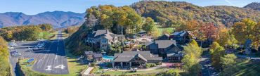 Scenic mountain lodge with private airstrip surrounded by autumn foliage.