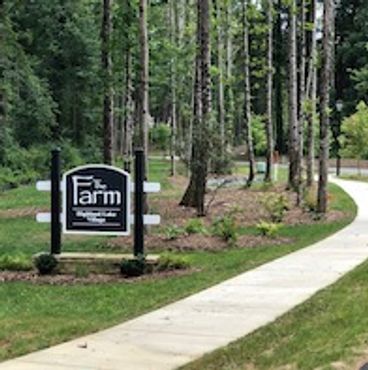 A winding sidewalk next to a sign for The Farm at Georgia Tech.