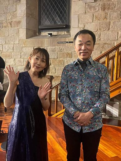 Two people standing indoors, smiling and posing for the camera.