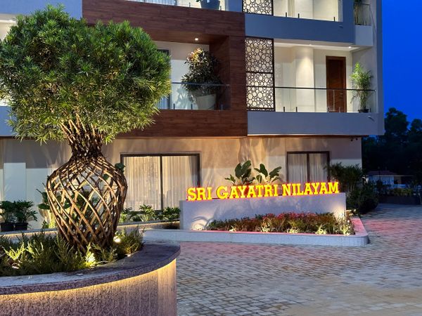 Illuminated entrance of Sri Gayatri Nilayam with modern landscaping and lighting.