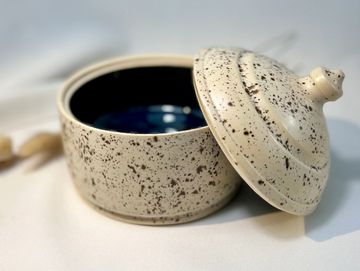 Speckled ceramic container with lid, featuring a glossy dark interior.