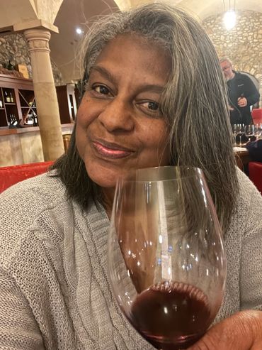 Greer holding up a glass of wine.
