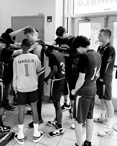 JV basketball team praying over a teammate who is starting a new adventure in life.