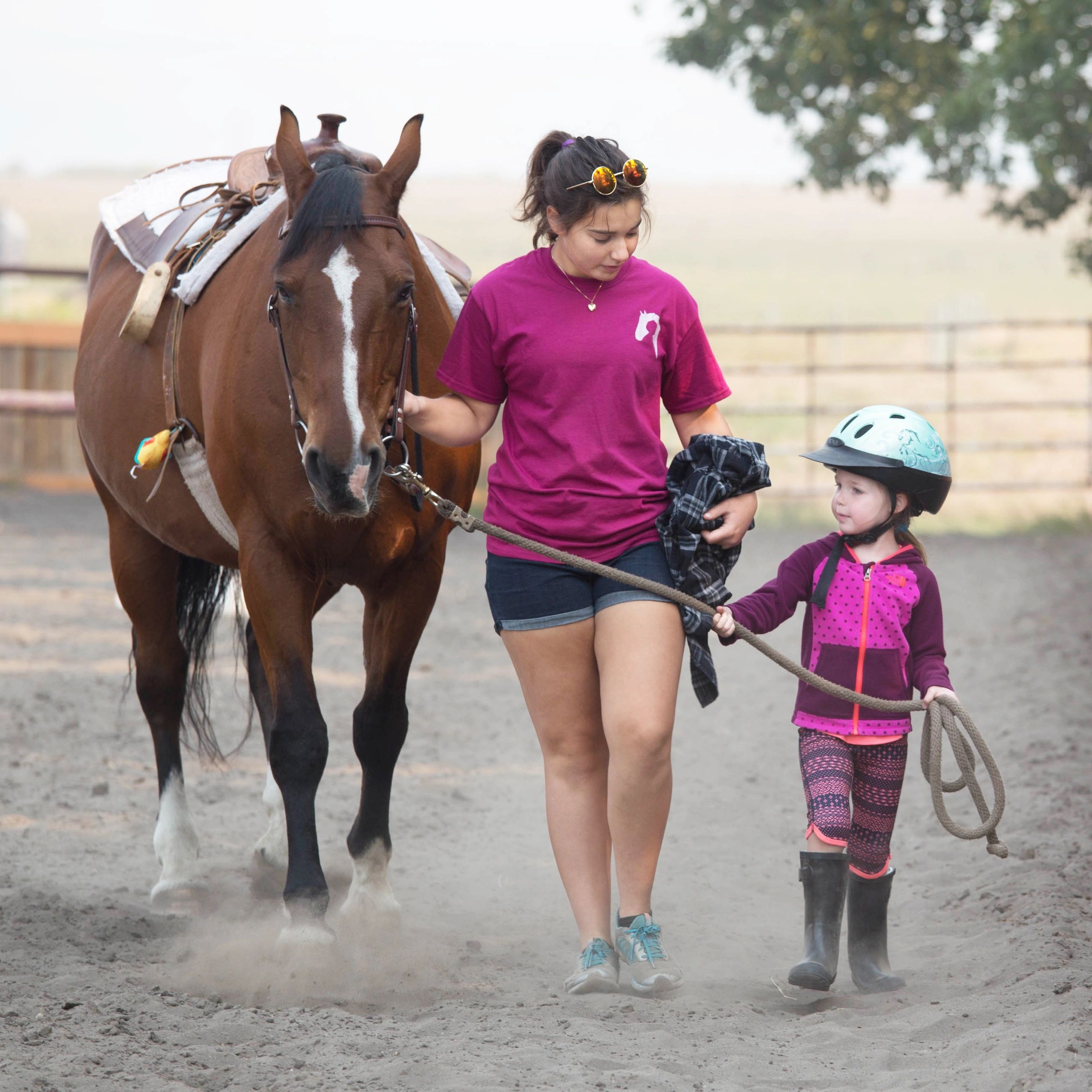 child and volunteer leading a horse
