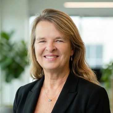 Professional woman smiling in a business setting.