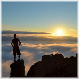 An imaginary figure of Jeff H. Ulrich standing on a high peak during the early morning light.