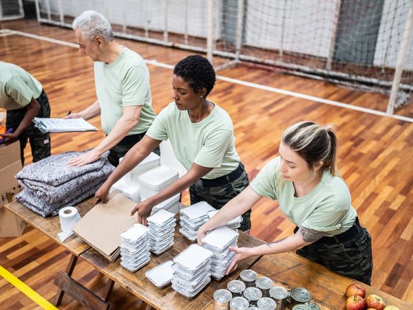 Two people sorting items in boxes.