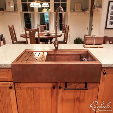 35" custom retrofit copper farmhouse sink in a white countertop and wood cabinets replaced porcelain