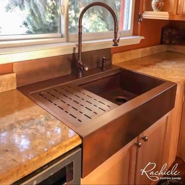 copper retrofit farmhouse sink with an integrated backsplash to help with a cracked granite issue.