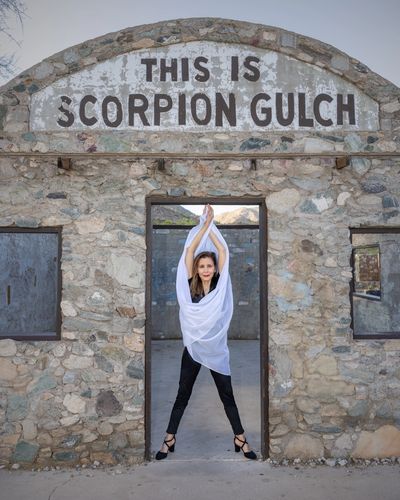 Woman posing in a white scarf in the doorway of Scorpion Gulch ruin.