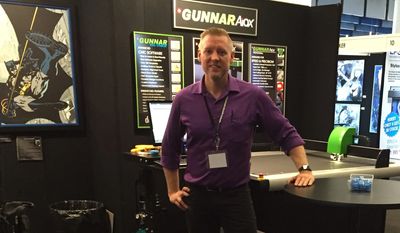 Jared Davis demonstrating computersied mat board cutting machinery at a tradeshow in Sydney