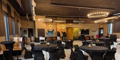 Spacious dining area with round tables and black chairs.
