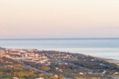 Vista panoramica di Roccella Ionica con il castello arroccato sul promontorio e la costa dei Gelsomi