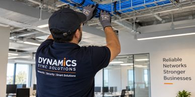 Technician working on network cables indoors.