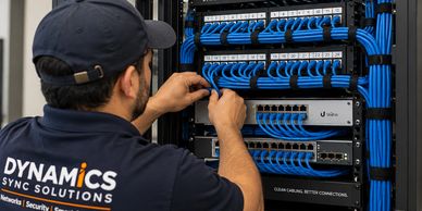Technician working on network cables in a server rack.