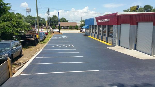 Newly paved parking lot at a Total Care Experts auto service center beside a Waffle House.