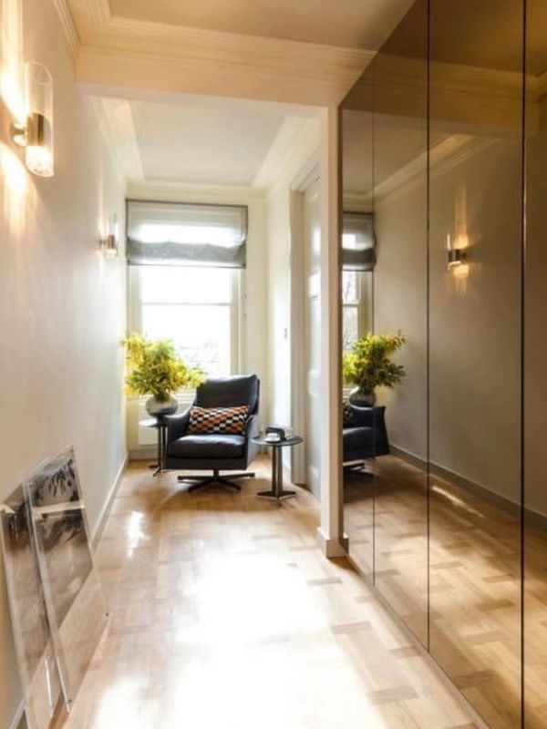 Cozy reading nook with a black armchair and side tables in a bright hallway.