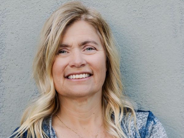 Smiling middle-aged woman with blonde hair.