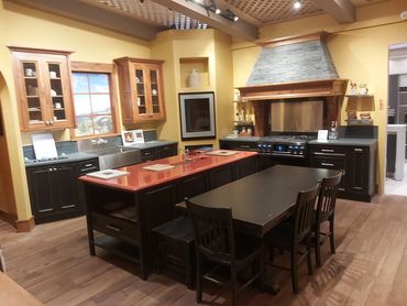 Rustic kitchen with wooden cabinets, a central island, and a dining table with chairs.
