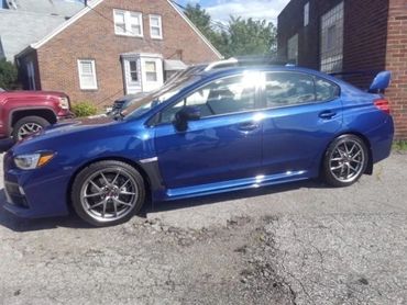 Blue Subaru Ceramic coated parked outside of Tint Pros Cleveland building