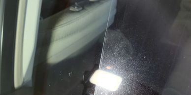 Image of a car glass with half of the window with water spotting/etching and the other half clear