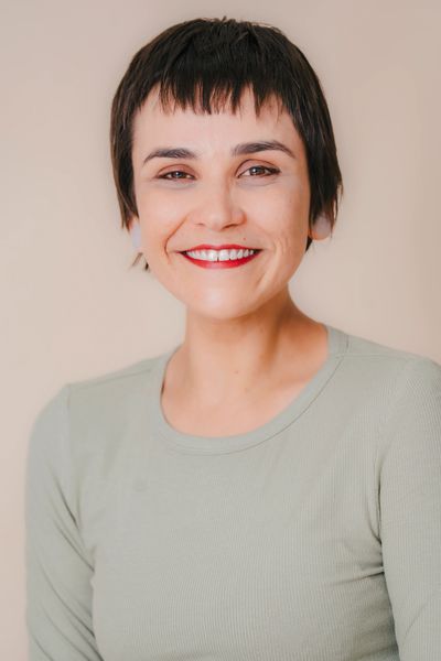 Woman with short dark hair smiling gently.