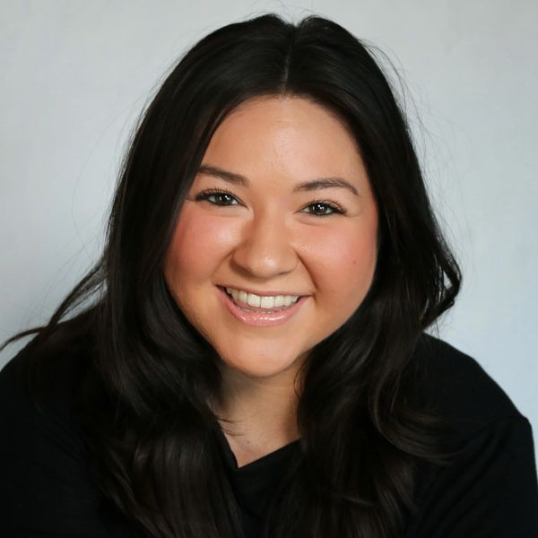 Smiling woman with long dark hair in a black top.