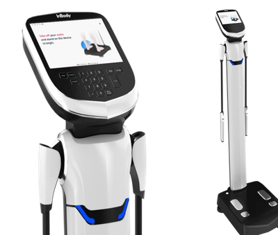 A sleek white and black body composition analyzer with a digital screen and footpads.