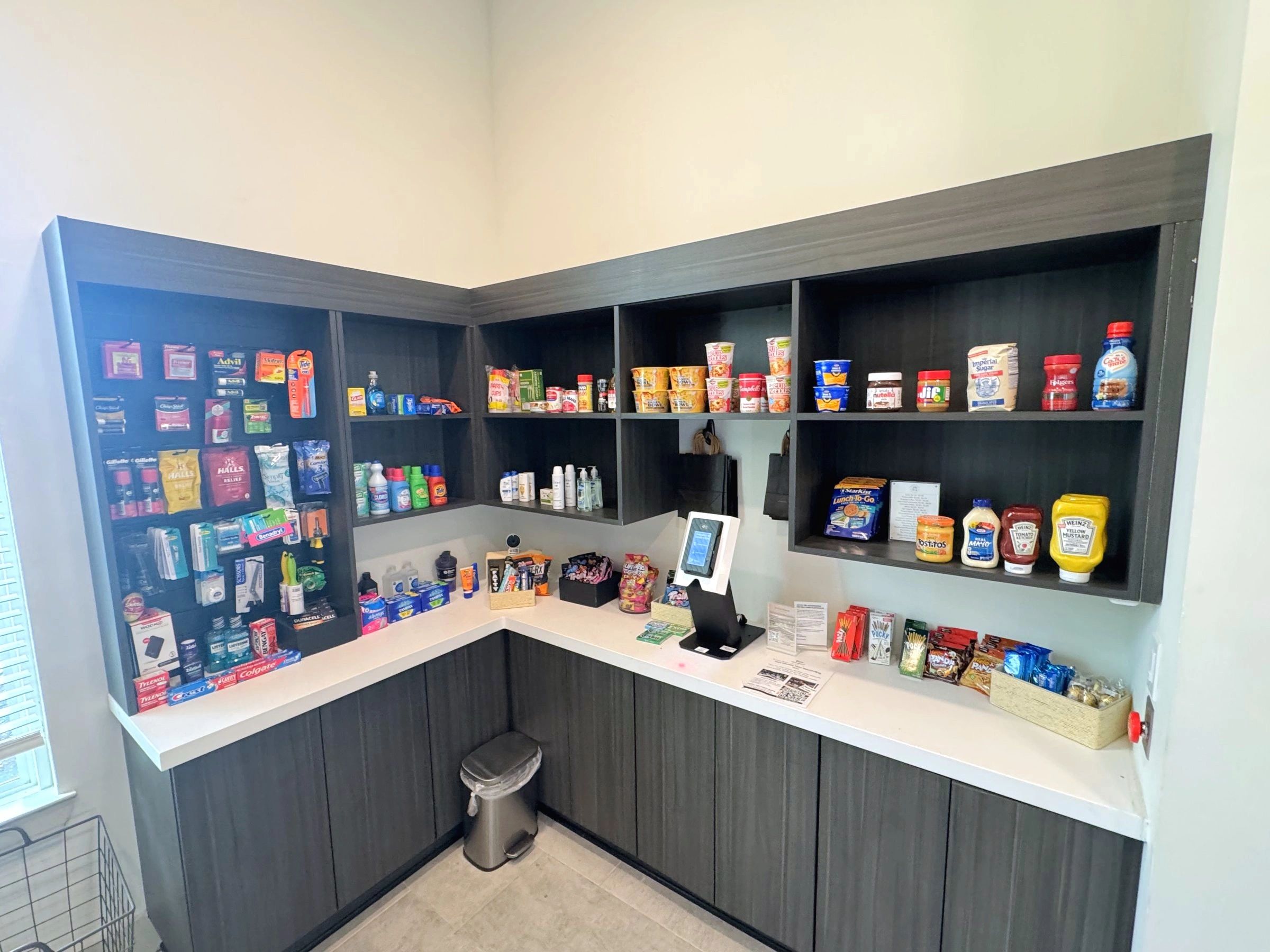 Corner micro market with stocked shelves and a self-checkout kiosk