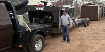 Shed delivery driver with trailer at lot of portable buildings – American Barn Co delivery team