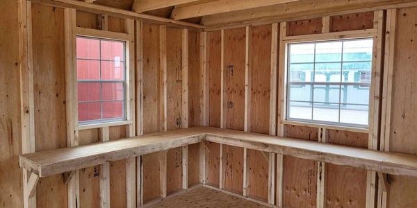 Unfinished shed interior with workbench and windows – custom portable building by American Barn Co