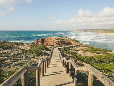 Long wooden walkway at the top of a cliff overlooking the ocean and beaches
