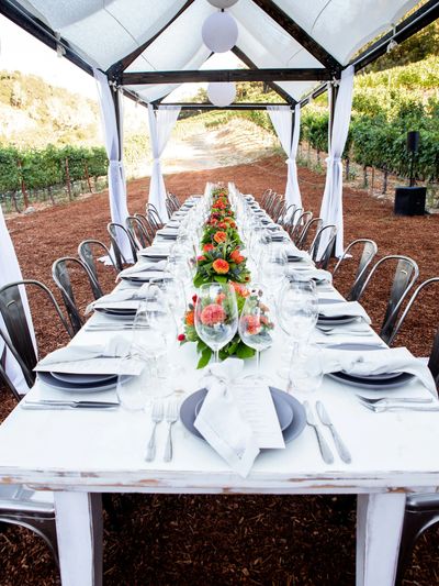 Large white table with place settings with white canopy over it