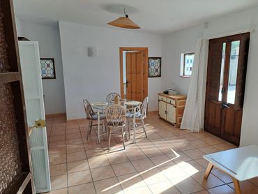 Bright dining room with rustic wooden furniture and tiled floor.